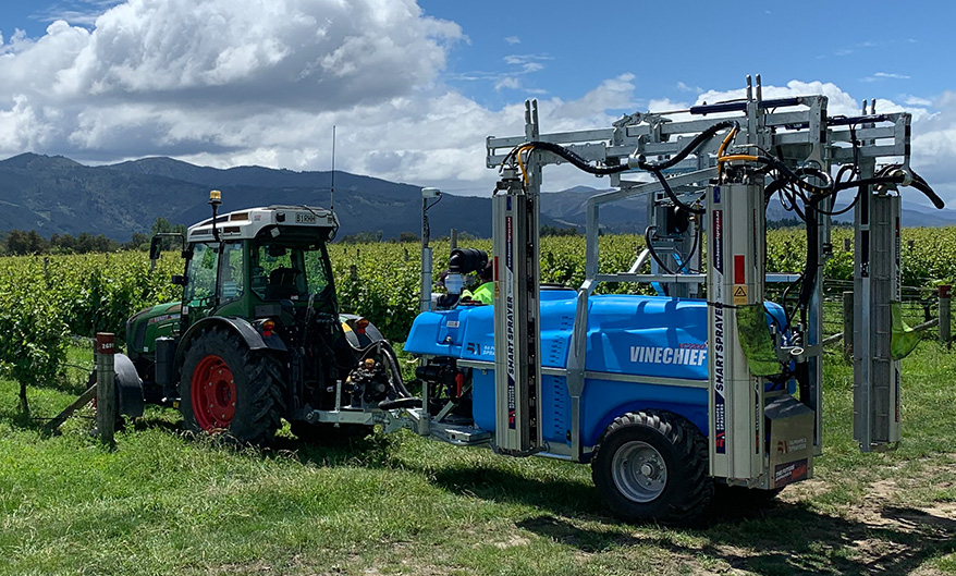 VineChief sprayer on a tractor going into a vine to spray