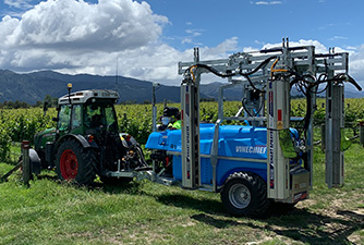 VineChief sprayer on a tractor going into a vine to spray