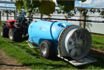 Orchard Sprayer on the back of a farm vehicle in an orchard