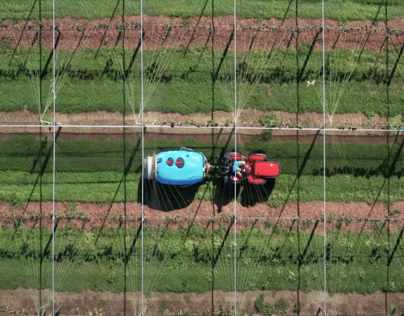 Aerial view of an Orchard Spraying being towed along by a tractor