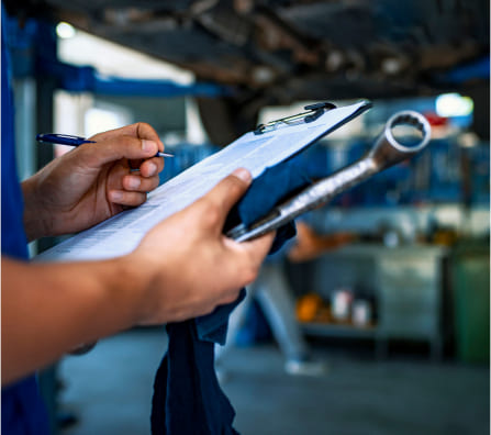 Person holding a clipboard and pen and checking off items in a list in the warehouse