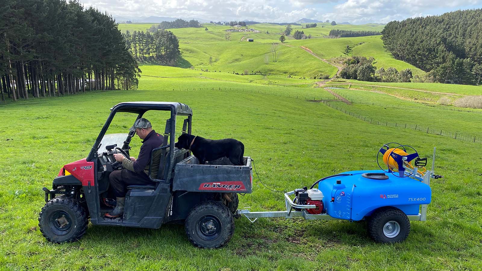 Farmer and his dog sat in the ATV with a TSX400 on the back