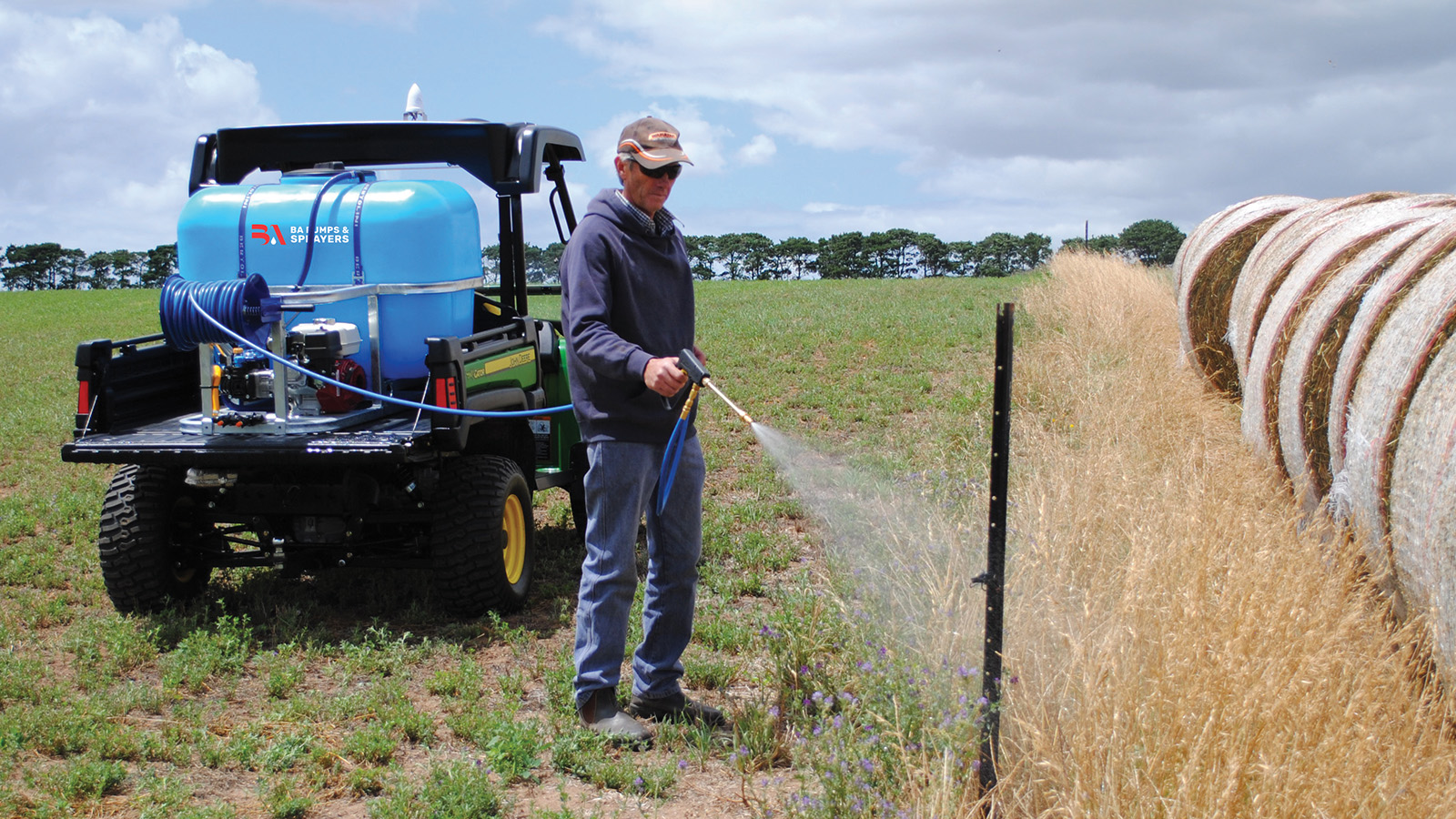 Man spraying the fenceline with a Deckmount Gun Sprayer