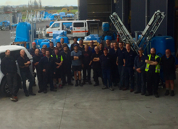 BA team outside the warehouse with an LS Linkage Sprayer in the background.