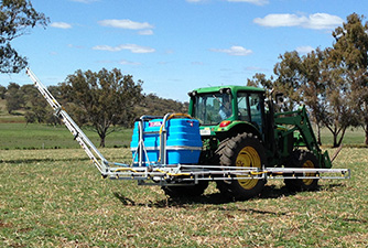 A tractor with a half opened boom in a field.