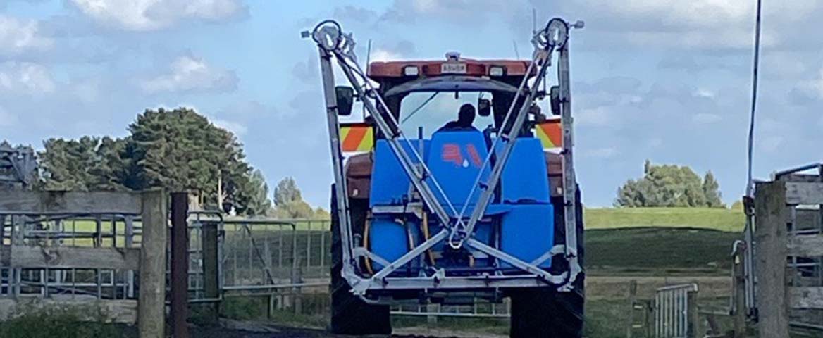 LM Linkage Sprayer on the back of a tractor heading off to spray